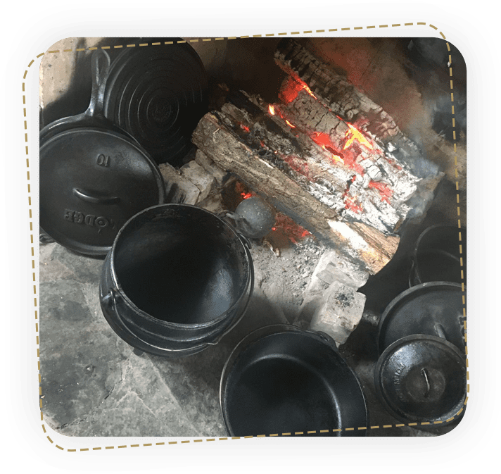 A group of black pots sitting on top of a fire pit.